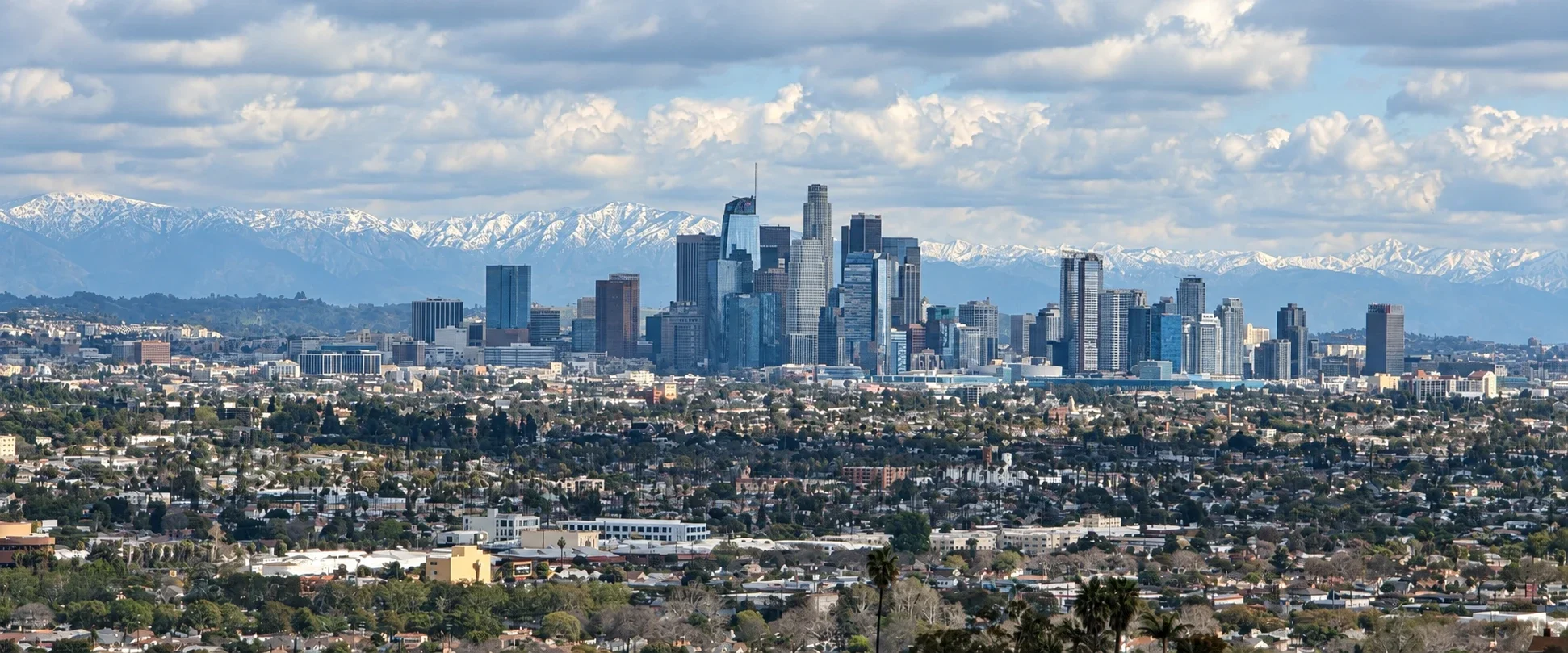 Downtown Los Angeles with snowy mountains and surrounding neighborhoods.